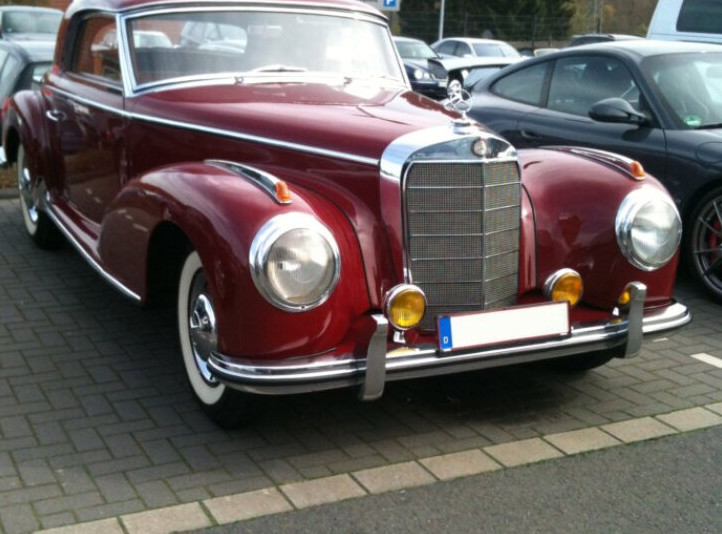 Roter Oldtimer vor der Werkstatt